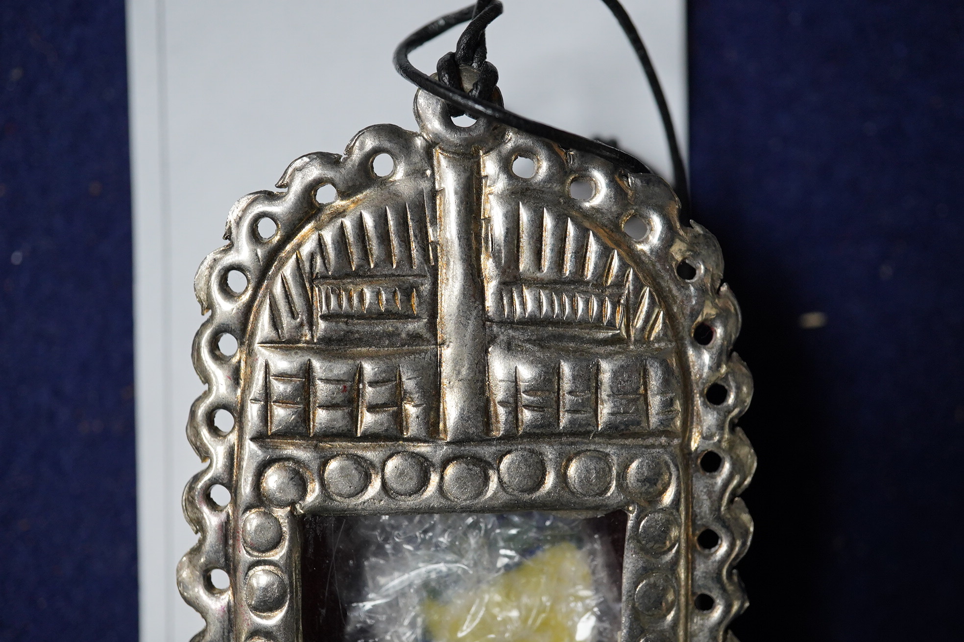 A Grayson Perry reliquary white metal pendant containing a section of tile, with Tate box, 7.5cm high. Condition - good